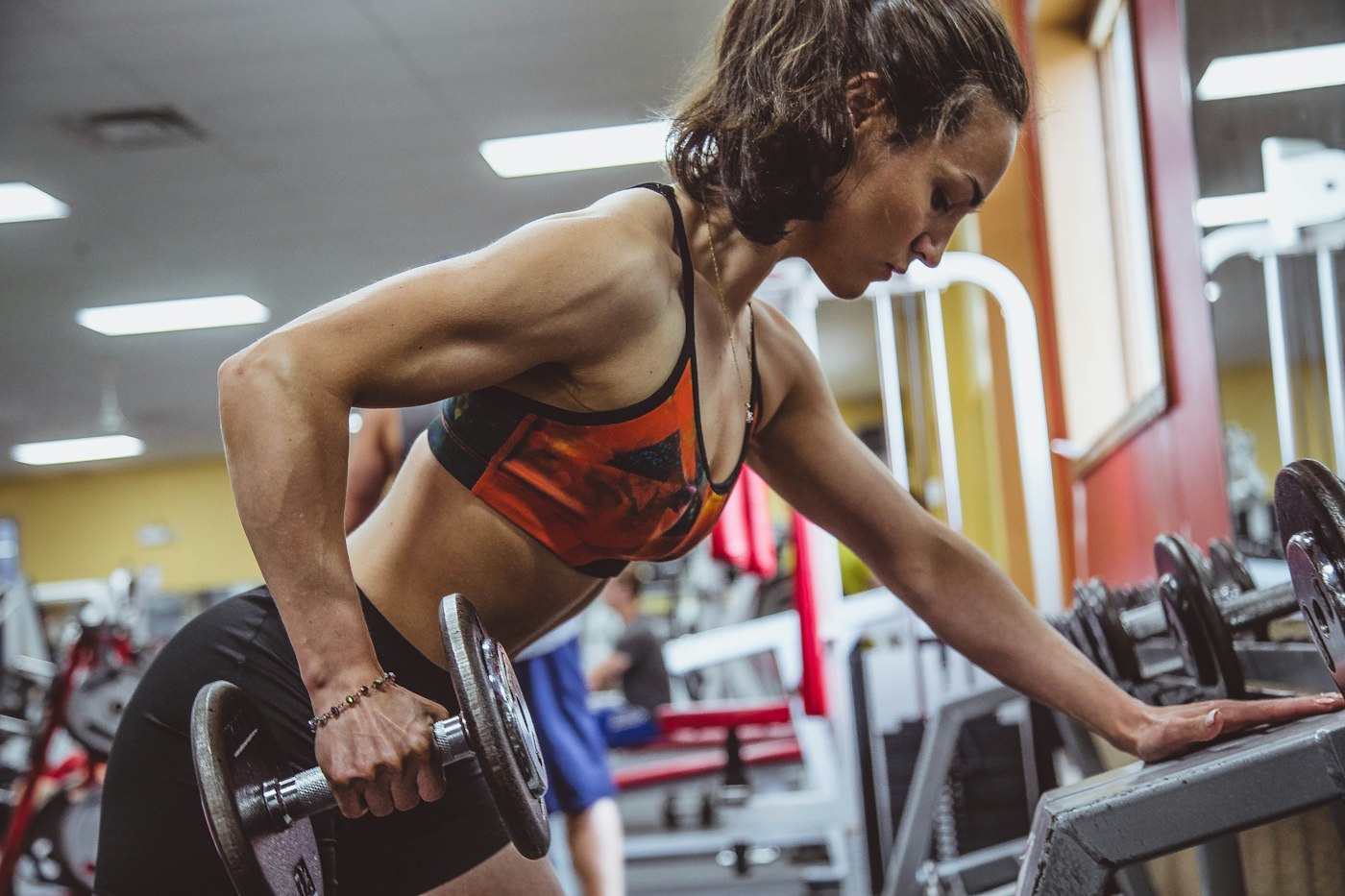 Woman performing a dumbbell row during resistance training in a gym