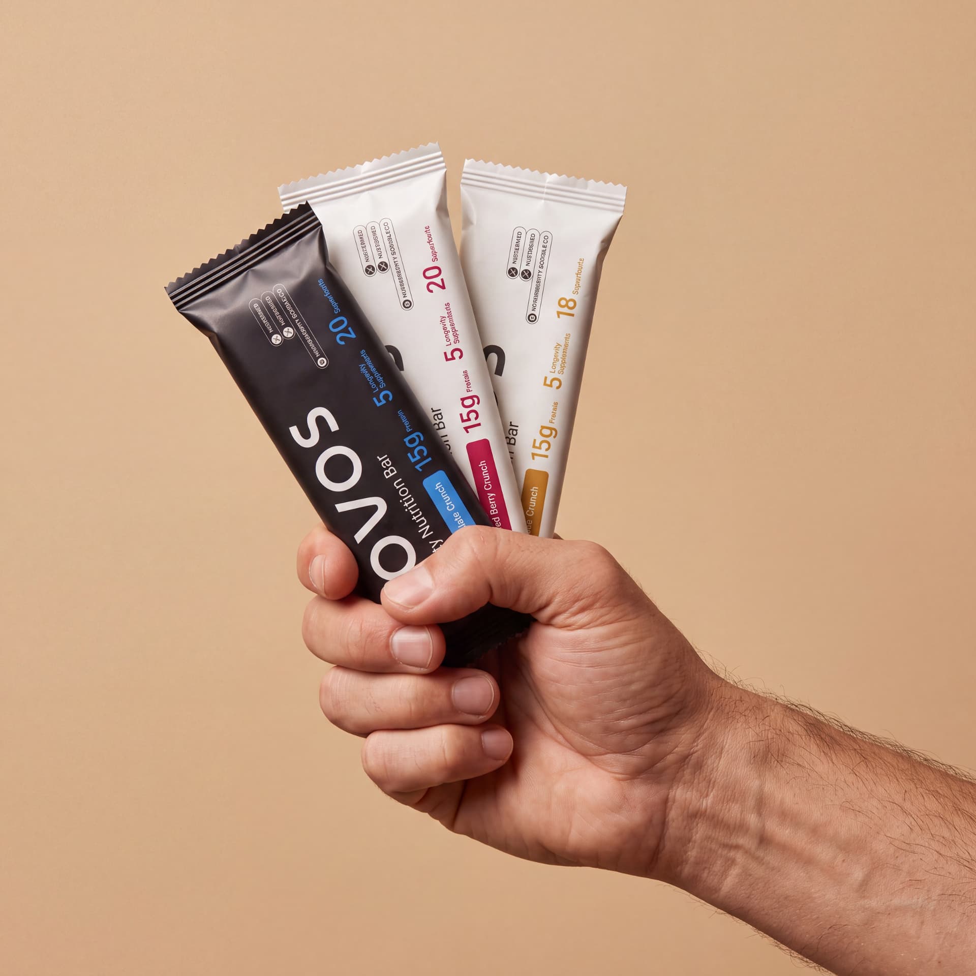 Hand holding the three NOVOS Bar flavors