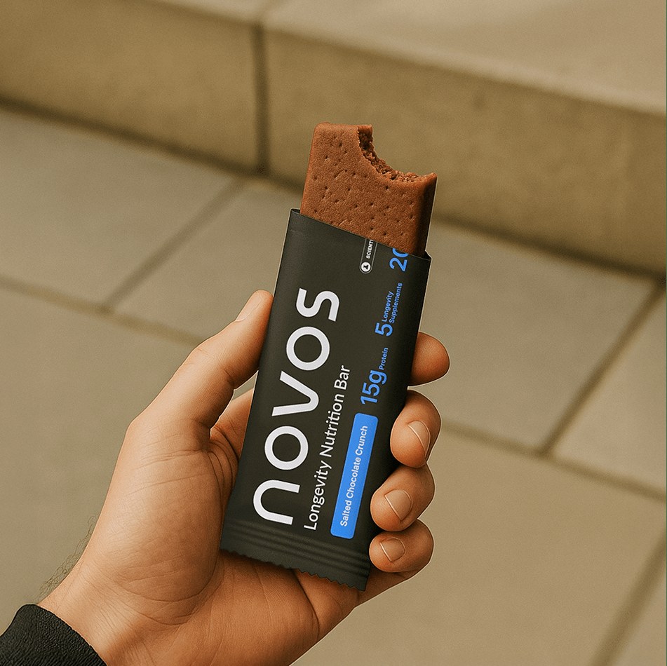 Hand holding an opened NOVOS Bar in its packaging