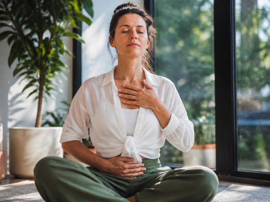 Person practicing calm breathing beside a sunlit window